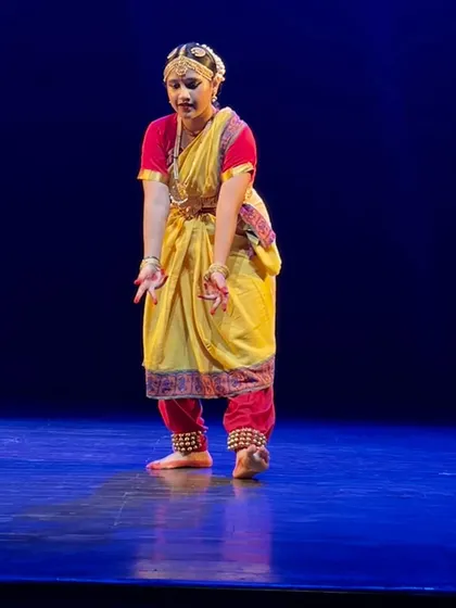 A moment of pure expression from a Bharatnatyam performance. Our classes focus deeply on `abhinaya` (facial expressions) and `mudras` (hand gestures) to tell stories with grace and devotion.