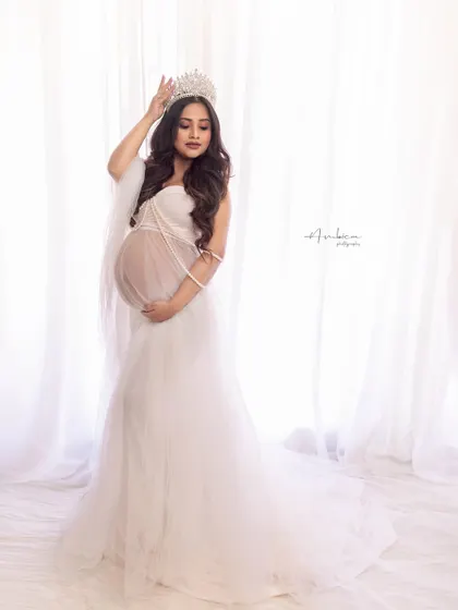 Slaying it like a queen. This portrait in a sheer white gown, complete with a crown and pearl details, is the epitome of regal elegance. Her pose is full of grace and confidence.