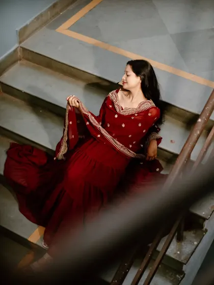 This shot, taken through the stair railing, creates a sense of looking in on a private, quiet moment. It adds an artistic, framed element to the portrait.