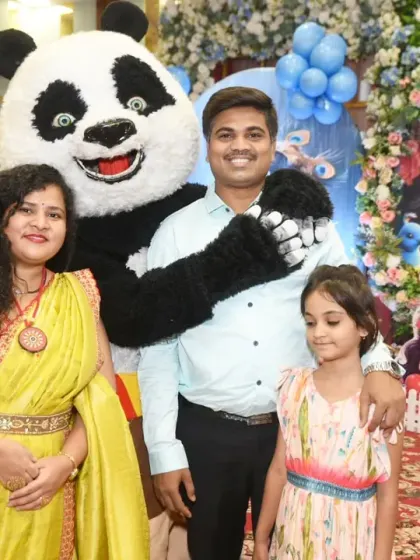 Another happy family posing with the panda mascot.