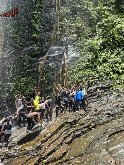 A large group celebrating under the powerful spray of Hidlumane falls on the Kodachadri trek. It is a moment of pure energy and excitement.