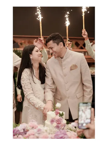 A celebratory cake-cutting moment from an engagement party. The sparklers held by friends and the couple's happy expressions perfectly capture the joy and excitement of this pre-wedding event.