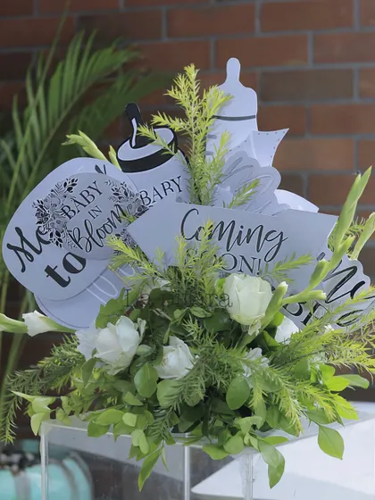 A bouquet of fun baby-themed photo props, like 'Baby in Bloom' and 'Coming Soon' signs.