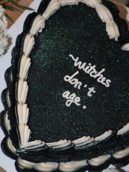 A close-up of our "witches don't age" cake, showing off the subtle green glitter that gives it a magical, sparkling finish.