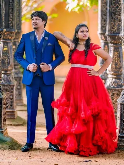 This couple chose a bold color combination for their pre-wedding shoot. The fiery red ruffled gown and the sharp blue suit create a powerful and stylish look.