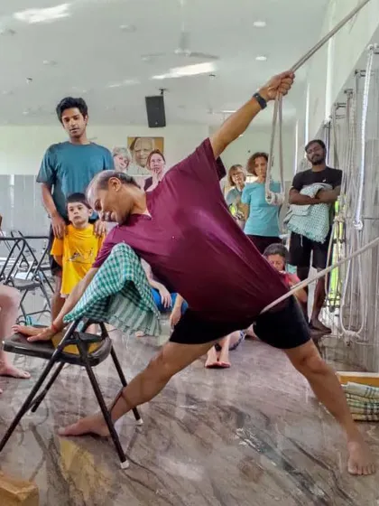 Teaching a standing pose with rope support during a festival. The large, open hall at our Ramanagara centre is perfect for big groups and dynamic practice.