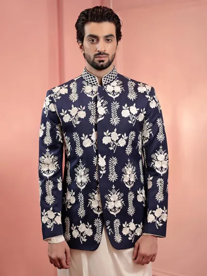 A navy Nehru jacket with all-over white floral embroidery. This piece is a beautiful example of contrast and detail, perfect for layering over a simple kurta.