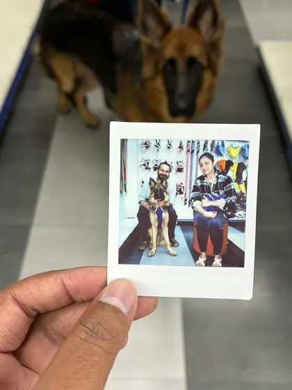 A polaroid keepsake from our Grooming Fest, capturing a happy moment between a German Shepherd and his family.