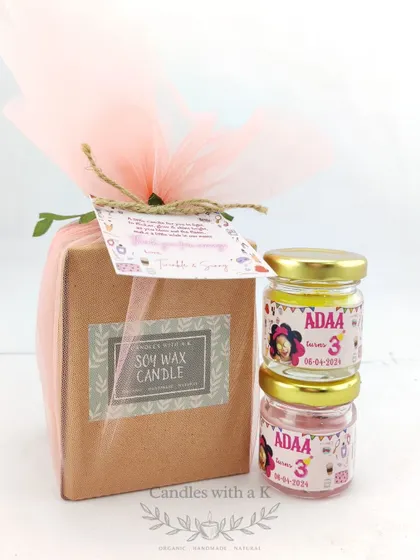 A spa-themed third birthday return gift, featuring a pack of two mini scented soy wax jar candles.