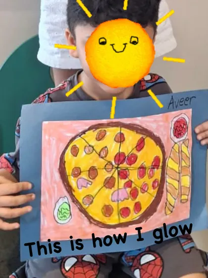 This student is glowing with pride after creating a delicious-looking pizza artwork. Our classes help children feel successful and capable, which shines through in their happy faces.