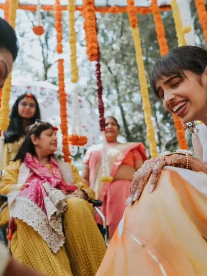 A bride shares a moment of uncontrollable laughter with her family during a pre-wedding ceremony.