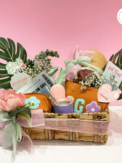 A bachelorette hamper designed for a day of fun and pampering. This basket includes personalized pouches, a salon voucher, and other essentials for the bride and her crew.