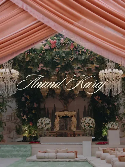 A title card for the 'Anand Karaj', set against the stunning floral and draped ceremony space, capturing the sacred and beautiful atmosphere.