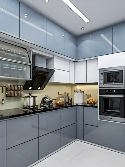 A sleek and functional L-shaped kitchen with glossy grey handleless cabinets. This design incorporates a tall unit for a built-in oven and microwave, frosted glass upper cabinets for lighter visual weight, and smart storage for spices and utensils.