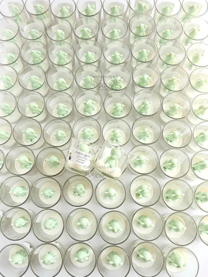 A large order of 100 teddy bear votive candles in pastel green, scented with lemongrass. This shows my capability to handle large, uniform orders for events.