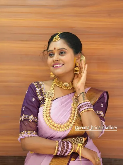 A happy portrait of the bride, highlighting her jhumkas and choker from the traditional rental set.