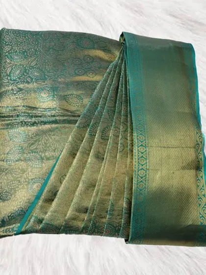 This stunning green silk saree with a detailed pattern is neatly pleated and boxed. It's a practical solution for keeping your valuable silks safe and ready for any event.