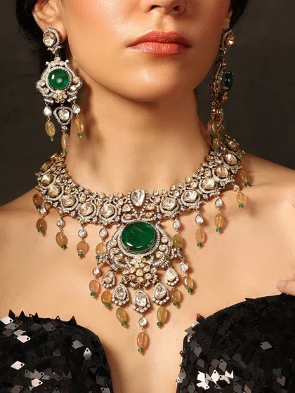 A breathtaking bridal necklace set featuring a large central emerald surrounded by intricate polki work and delicate drops, perfect for a grand wedding celebration.