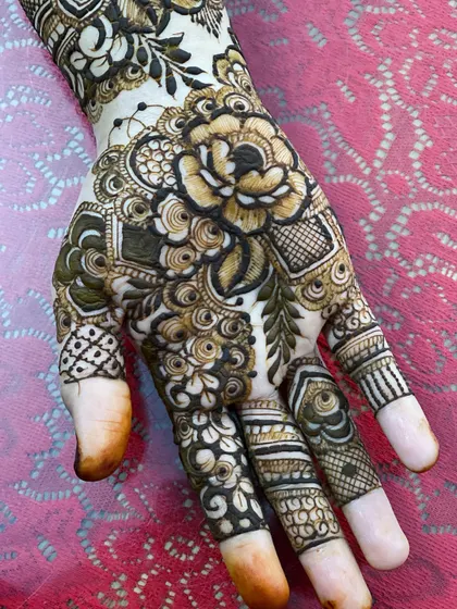 A close-up on the hand and fingers, where the floral patterns are intricately detailed to adorn every part of the hand.