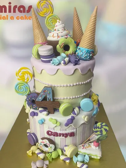 A magnificent two-tier candyland cake. This creation is a fantasy of sweets, adorned with ice cream cones, donuts, lollipops, and macarons, perfect for a truly sweet celebration.