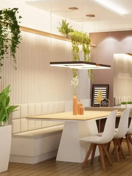 A dining area with bench seating on one side to save space. The design incorporates natural elements like wood and hanging plants for a fresh, biophilic feel.