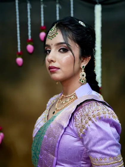 A side profile showing the elegant earrings and the intricate braid, giving a complete picture of the bridal hairstyle and accessories.