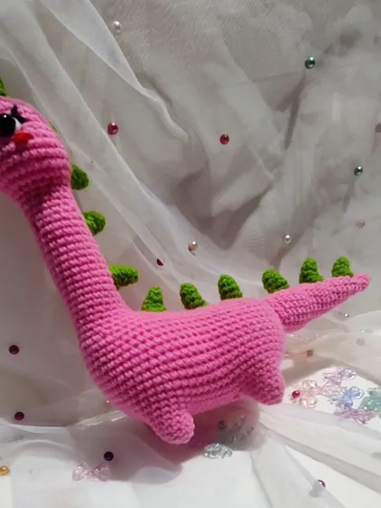 A side view of the adorable pink dinosaur.