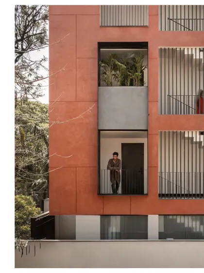 The design incorporates recessed balconies and large windows, breaking up the monolithic facade. These openings not only provide light and air but also offer tenants a direct connection to the tree canopy and the outdoors.