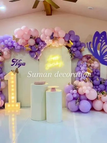 The complete butterfly-themed first birthday setup, including the light-up number '1' and the name 'Niya' on the backdrop.