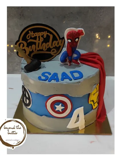 An Avengers inspired cake for a young superhero fan. This design features logos of Thor, Captain America, and Iron Man, and is topped with a dynamic Spiderman figure.