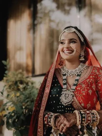 A beautiful, happy bride glowing in the natural light. Her makeup is kept fresh and radiant to complement her intricate wedding attire.