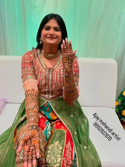 A full-length shot of the bride, showing how the beautiful mehndi on her arms and hands completes her festive look.