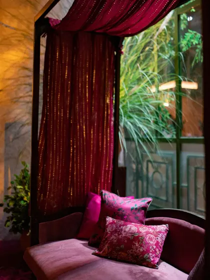 An intimate seating nook with a draped canopy, creating a private, luxurious space for guests.