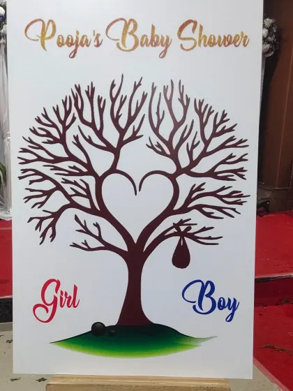 A creative "Girl or Boy" gender reveal sign for a baby shower, designed with a tree of life graphic.