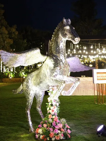 A majestic mirrored Pegasus statue serves as a stunning statement piece for a glamorous outdoor sangeet.