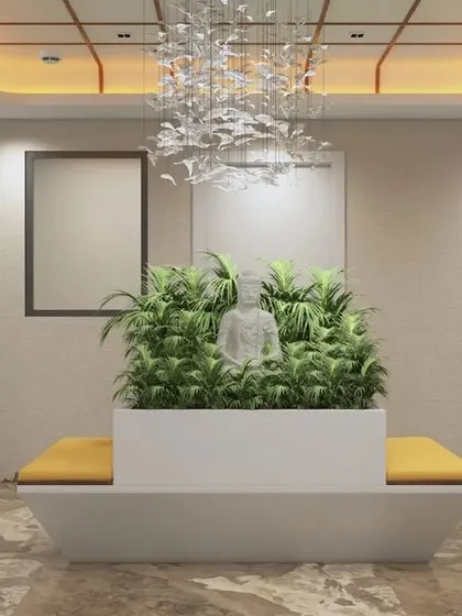 A central waiting lounge featuring a custom planter bench with an integrated Buddha statue, creating a tranquil focal point. This space provides a serene break-out area for employees and visitors.