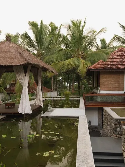This project, the Niraamaya Holiday Resort in Kovalam, involved restoring and relocating traditional Keralan wooden houses. Here, a thatched-roof gazebo sits beside a lily pond, creating a tranquil space that is rooted in local architectural traditions.