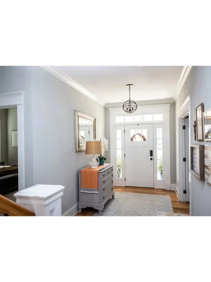 A bright and traditional entryway. The classic door with sidelights, elegant console table, and warm lighting create a timeless and welcoming entrance.