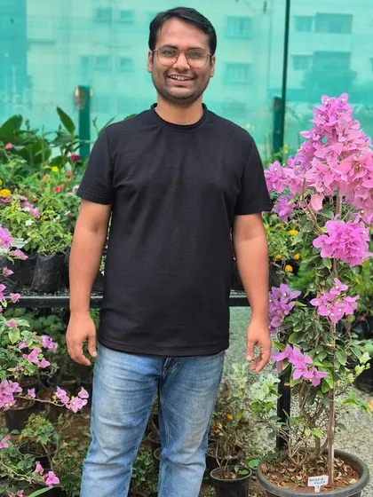 My husband and partner in this dream, standing among the vibrant bougainvillea. His support and hard work have been the foundation of Urban Jungle.