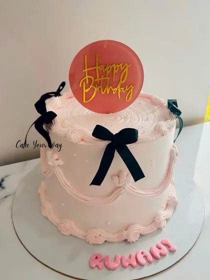 A trending vintage cake in pink and black, with delicate piping and bows.
