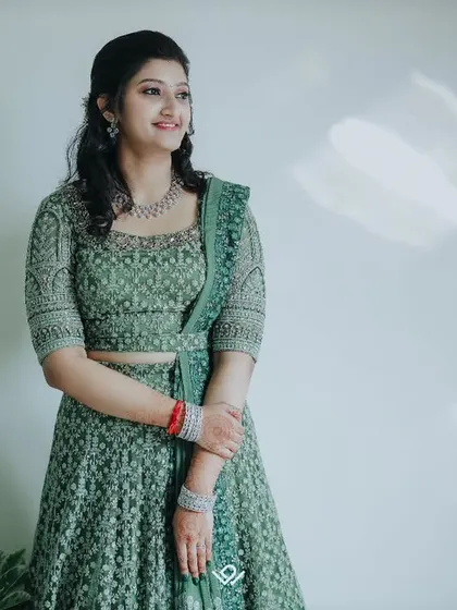 A simple and elegant portrait of a woman in a green lehenga, her calm and happy expression captured beautifully.