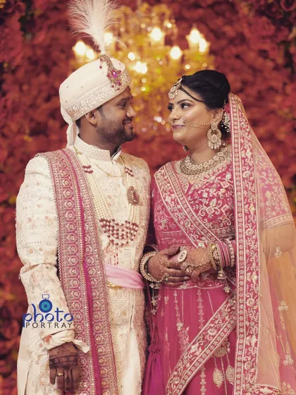 A classic, romantic portrait of the wedding couple looking at each other, set against a beautifully lit, warm backdrop.