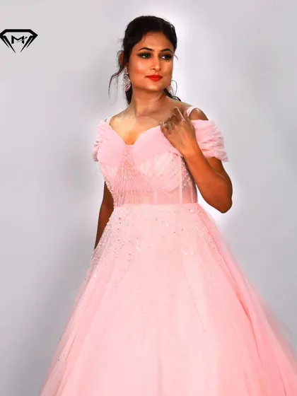 A soft and romantic baby pink ball gown. The off-shoulder design and sparkling beaded bodice create a classic princess look, perfect for any fairytale occasion.