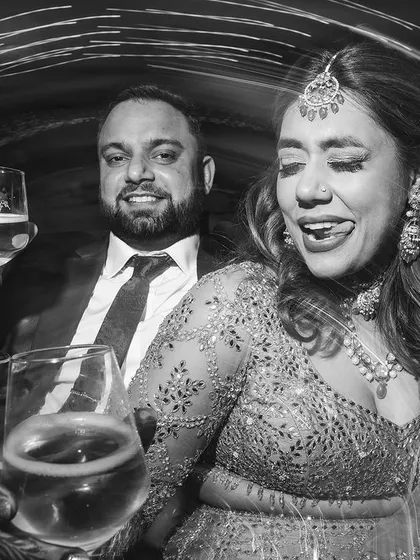 A fun and candid black and white shot of the couple toasting to their new life together. Their expressions are full of joy and a little bit of mischief.