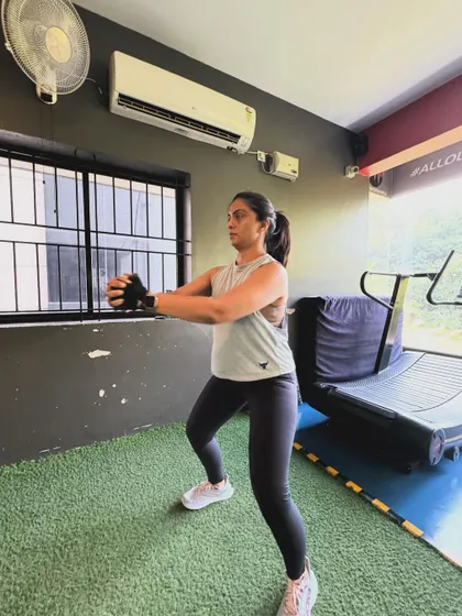 A client performs a goblet squat, focusing on maintaining an upright chest and proper depth.