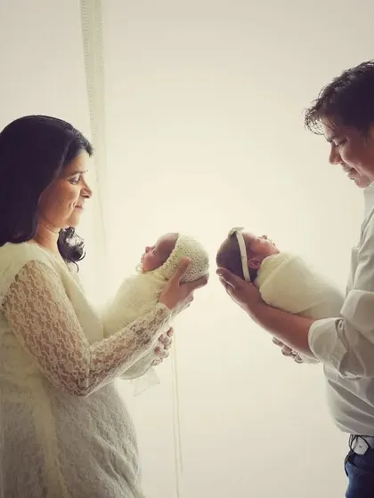 Another beautiful angle from the twin family session. The soft lighting creates a dreamy, gentle mood as the parents admire their two new babies.