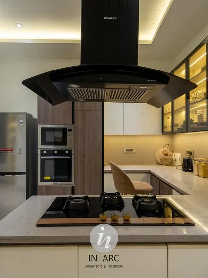 A perspective from the island cooktop, looking towards the built-in appliances. The island chimney acts as a strong focal point while ensuring the kitchen remains fresh and smoke-free.