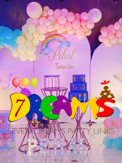 A custom rainbow-themed decoration with soft pastel colors. This setup uses two arched backdrops and an organic balloon garland to create a dreamy and modern look.