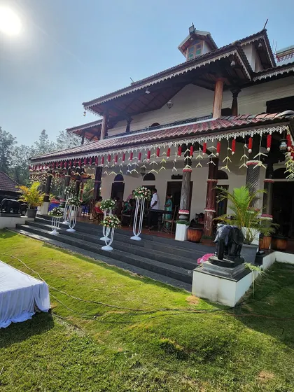 This wide view shows how we integrate our decor with the venue. The traditional floral hangings and arrangements on the steps of this beautiful Malnad home create a cohesive and festive look for the wedding.