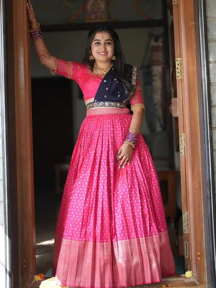A beautiful bride in a vibrant pink and navy blue Langa Dhawani, a perfect outfit for pre-wedding festivities.